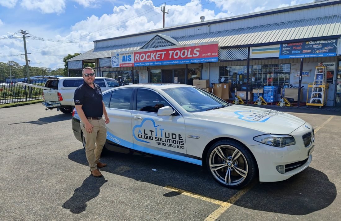 ACS director with an Altitude Cloud Solutions car outside a Taree business