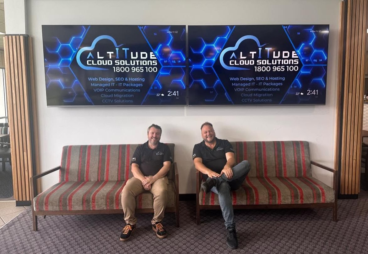 The ACS team at a local club in front of digital screens showing Altitude Cloud Solutions